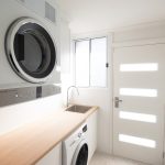 Laundry with wooden counter and cupboard
