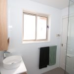 White bathroom with wooden accents