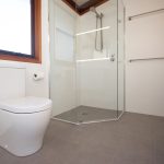 Bathroom with stone tiled floor and white tiled walls